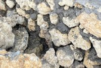 Foto: terdapat lubang cukup besar di bagian bawah dinding, dan ikatan antara batu serta semen terlihat tidak kuat atau tidak terisi penuh.