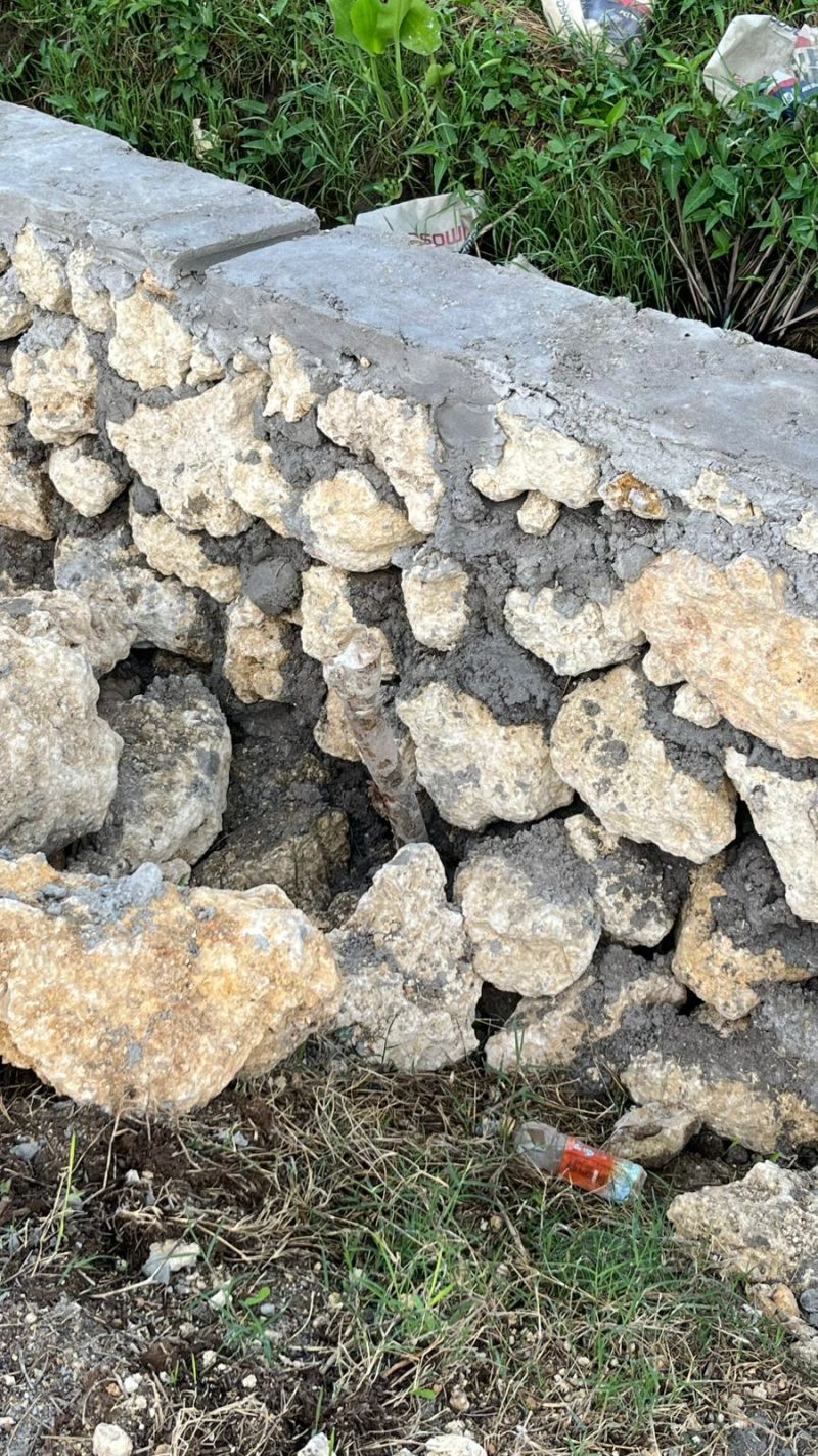 Foto: terdapat lubang cukup besar di bagian bawah dinding, dan ikatan antara batu serta semen terlihat tidak kuat atau tidak terisi penuh.